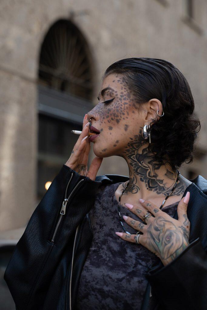 Ritratto di modella con tatuaggi e piercing durante la Milano Fashion Week.