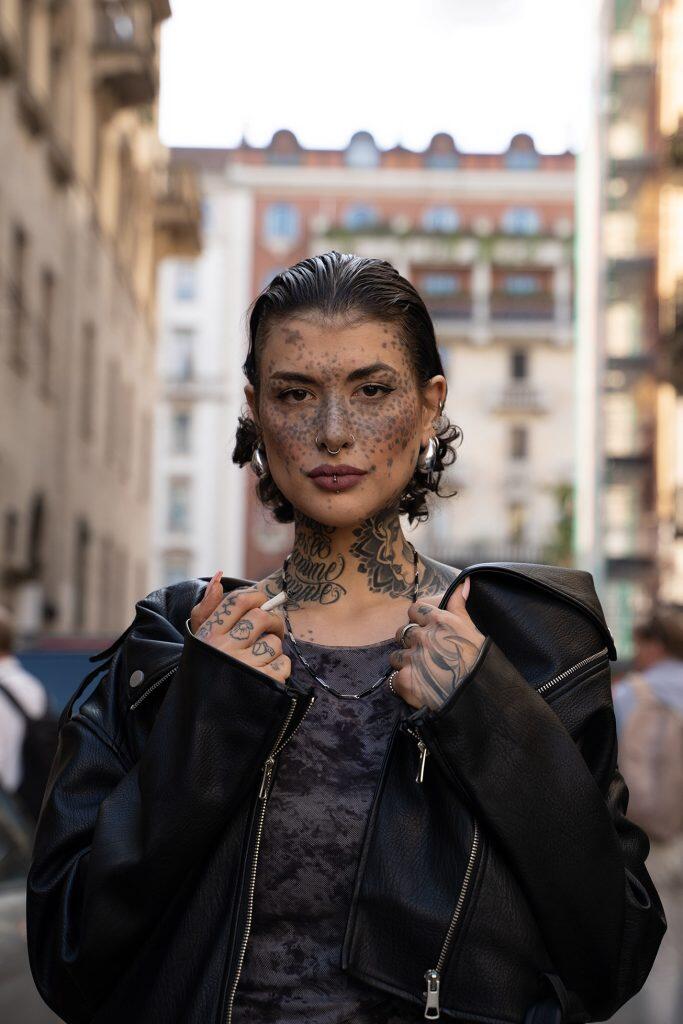 Modella alla Milano Fashion Week con giacca in pelle nera e look street style contemporaneo.